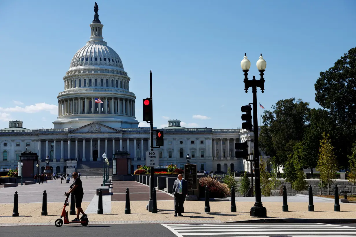 A man passes by the U.S. Capitol on his scooter in Washington