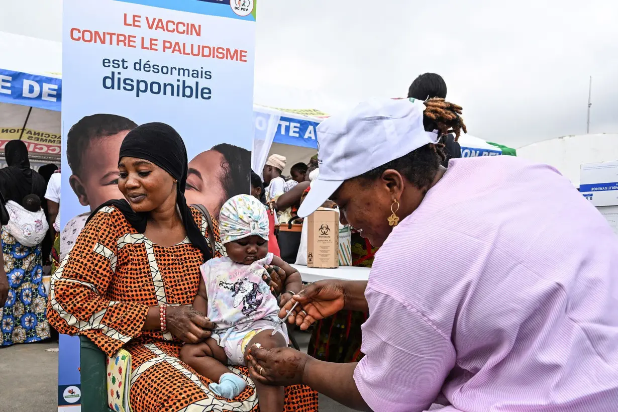 A health worker vaccinates a baby against malaria during the launch of a vaccination campaign at a commune in Abidjan, West Africa.