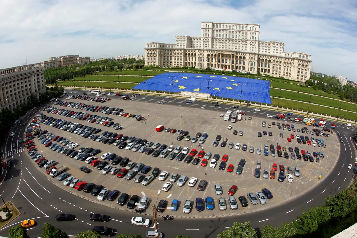 A large European Union flag is displayed in front of Romania's Parliament Building to mark EU Day in Bucharest