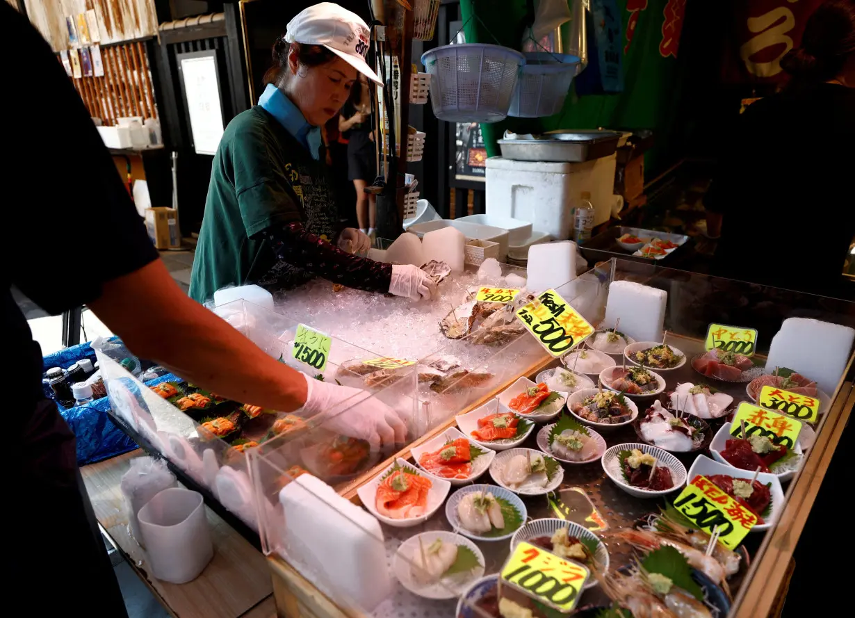 Vendors prepare seafood for sale at Tsukiji Outer Market in Tokyo