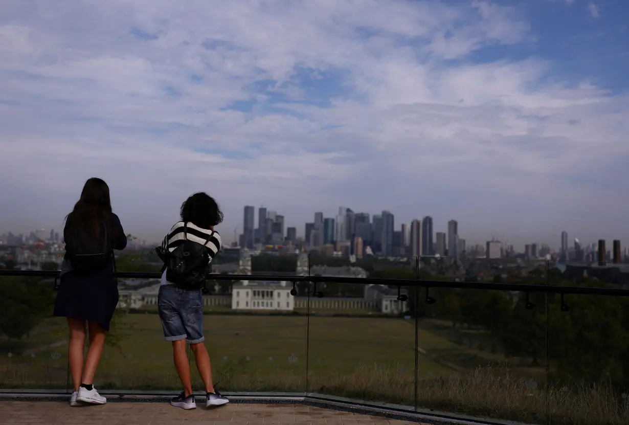 FILE PHOTO: People look out to Canary Wharf financial district from Greenwich Park in London