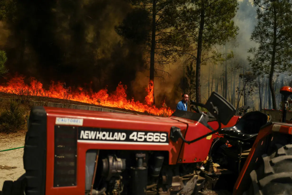 A local walks near to a wildfire in Sao Pedro do Sul