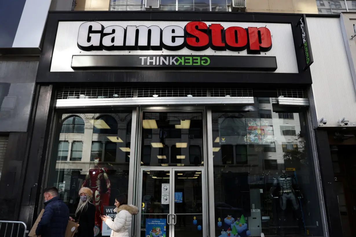 FILE PHOTO: People walk by a GameStop in Manhattan, New York