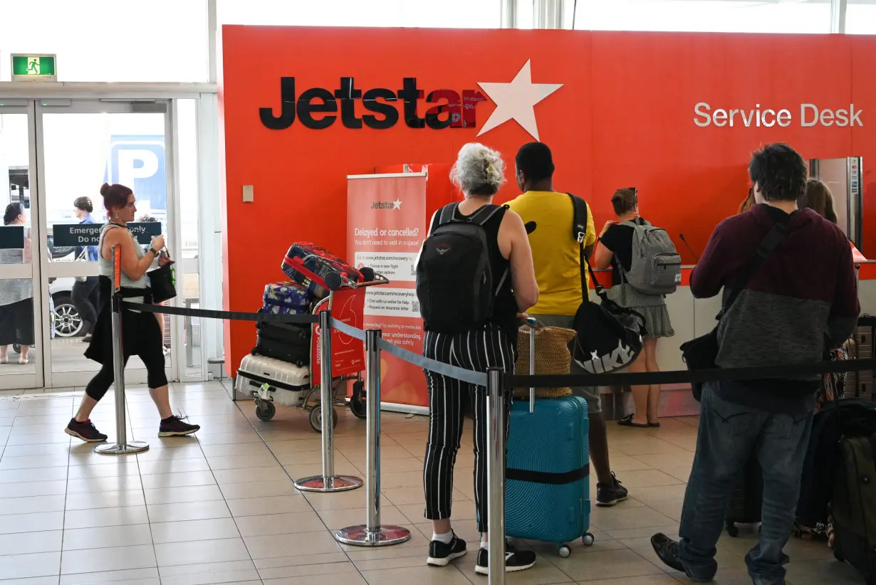 Travelers wait in line at a Jetstar Airways counter at Kingsford Smith International Airport in Sydney