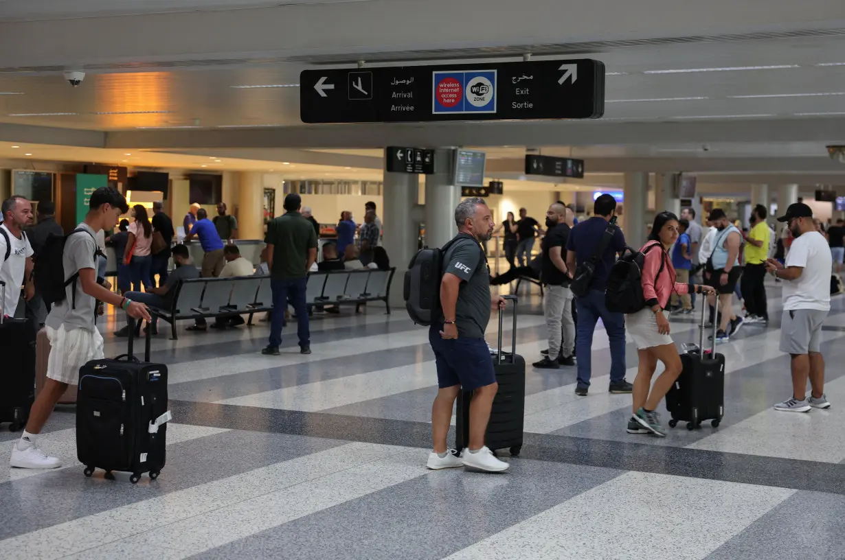 People walk with their luggages at Beirut-Rafic Hariri International Airport, in Beirut