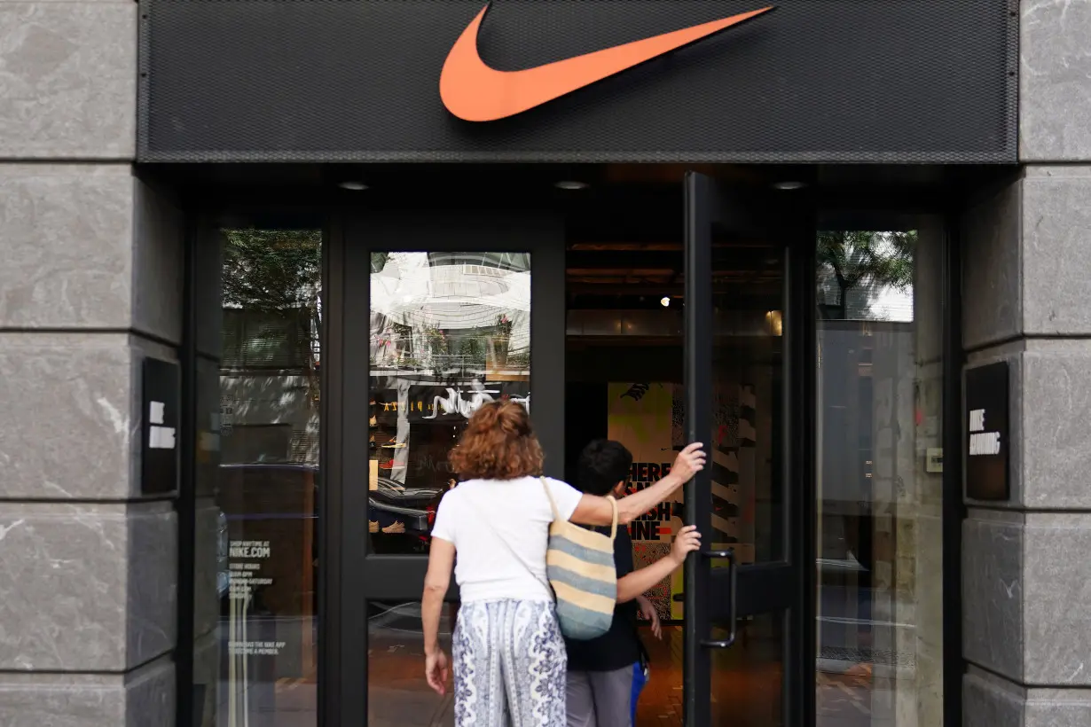 People walk into a Nike store in New York City,