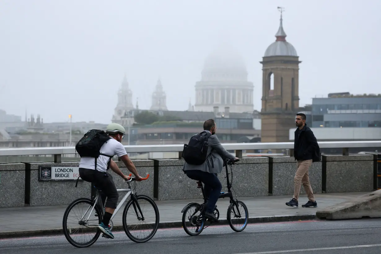 FILE PHOTO: Commuters cycle across London Bridge during the morning rush hour, in London