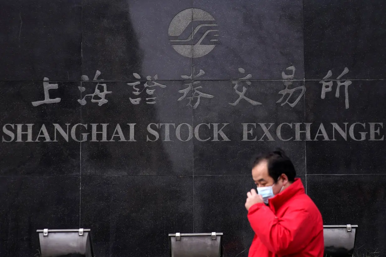 A man walks past the Shanghai Stock Exchange building at the Pudong financial district in Shanghai