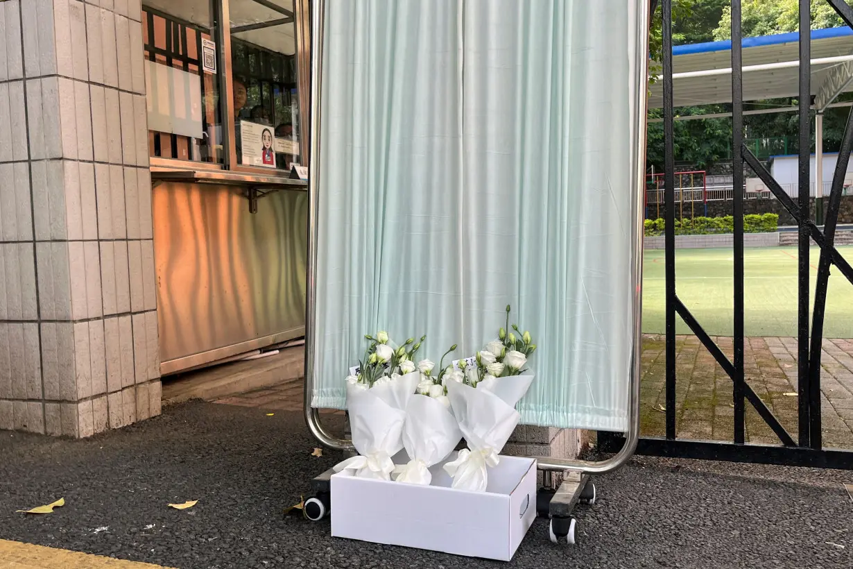 Flower bouquets lay outside Shenzhen Japanese School in Shenzhen