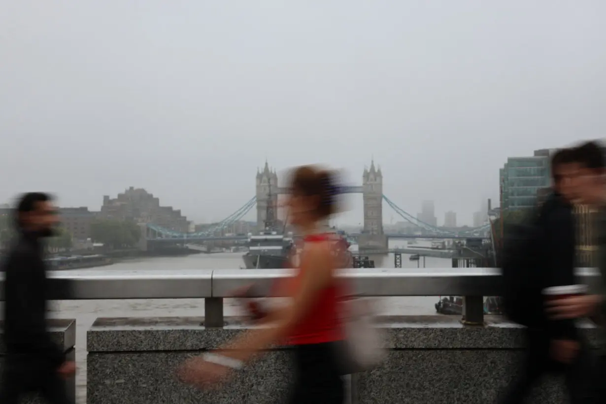 FILE PHOTO: People walk across London Bridge during the morning rush hour, in London