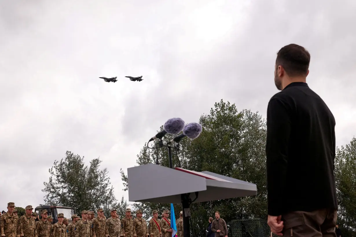 Ukraine's President Zelenskiy looks at F-16 fighter aircraft on the Day of the Ukrainian Air Forces in an undisclosed location in Ukraine