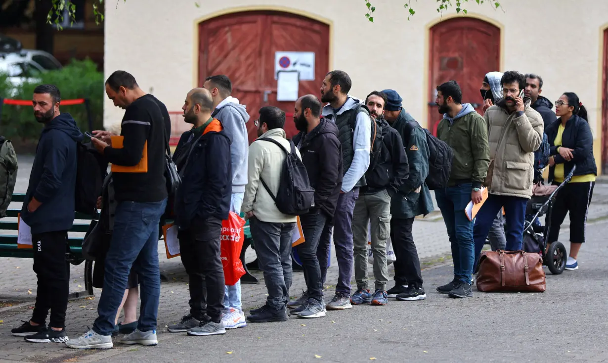 FILE PHOTO: Migrants queue at the arrival centre for asylum seekers at Reinickendorf district in Berlin