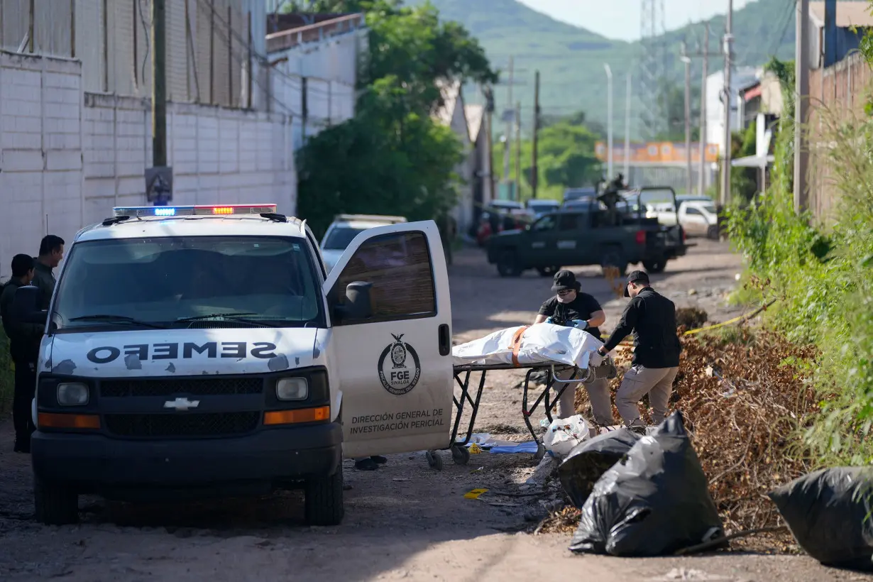 Forensic investigators remove a body from the street in La Costerita, Culiacan, Sinaloa state, Mexico, Sept. 19, 2024.