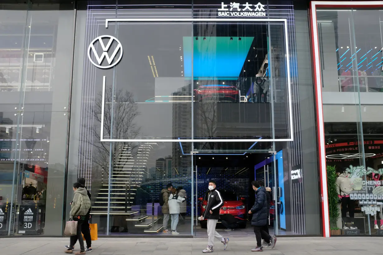 FILE PHOTO: People walk past an ID. Store X showroom of SAIC Volkswagen in Chengdu