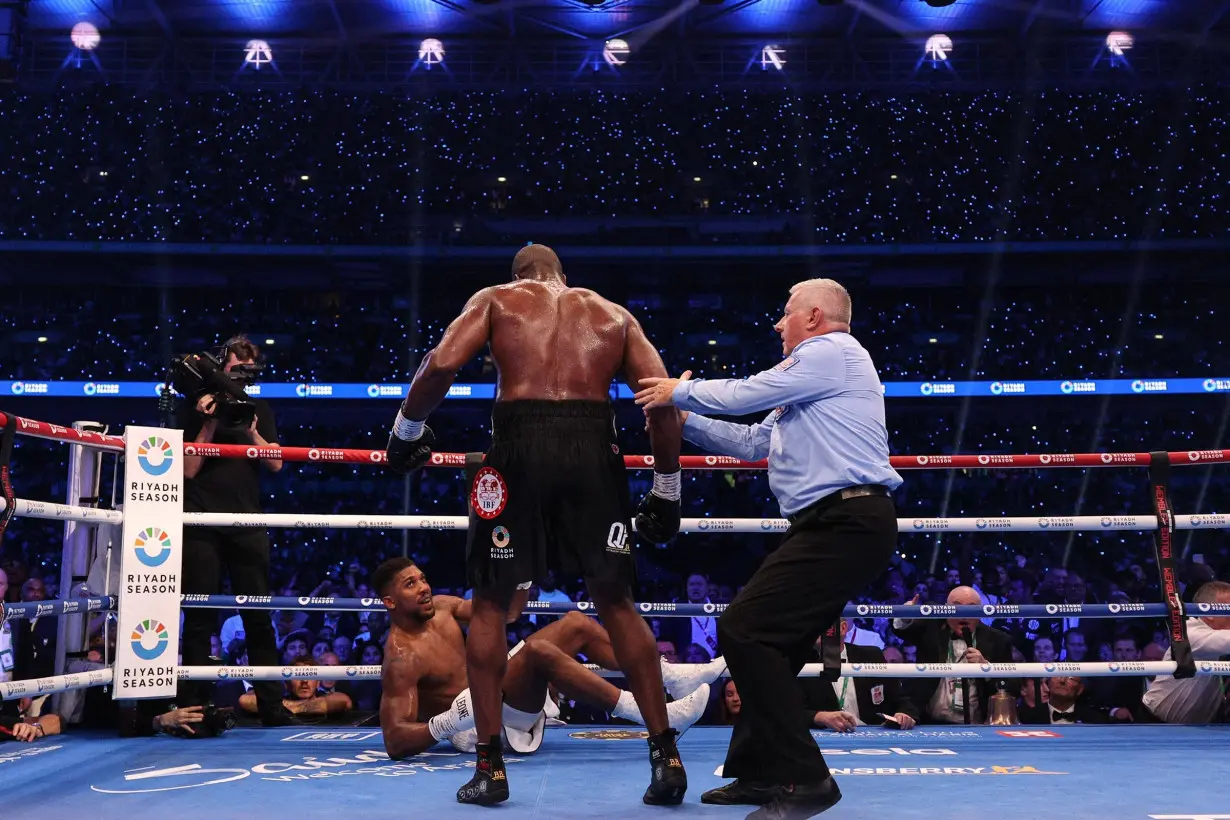 Anthony Joshua is knocked to the ground by Daniel Dubois during their heavyweight boxing match for the IBF world title at Wembley Stadium in London.