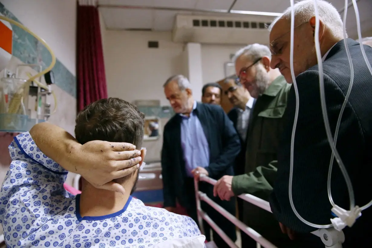 FILE PHOTO: Iran's President Masoud Pezeshkian visits one of the victims injured by pager explosions across Lebanon, in a hospital in Tehran