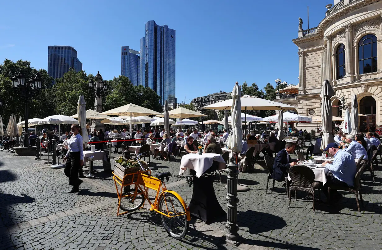 FILE PHOTO: People enjoy lunch next to the old opera house in the financial district in Frankfurt