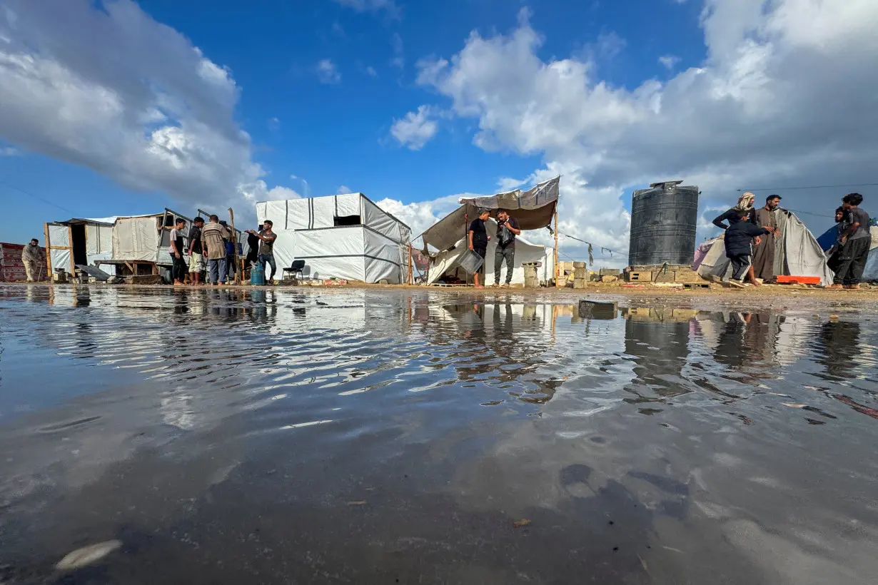 Displaced Palestinians gather as they shelter in a tent camp which was flooded following rainfall, amid the Israel-Hamas conflict, in Khan Younis, in the southern Gaza Strip