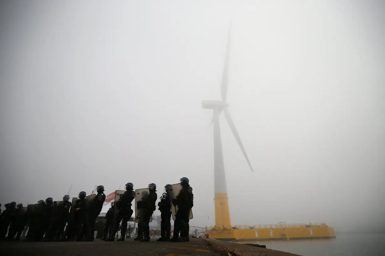 FILE PHOTO: French riot police take position as part of a demonstration by dockers during the inauguration of the first French offshore floating wind turbine, Floatgen, in the port of Saint-Nazaire