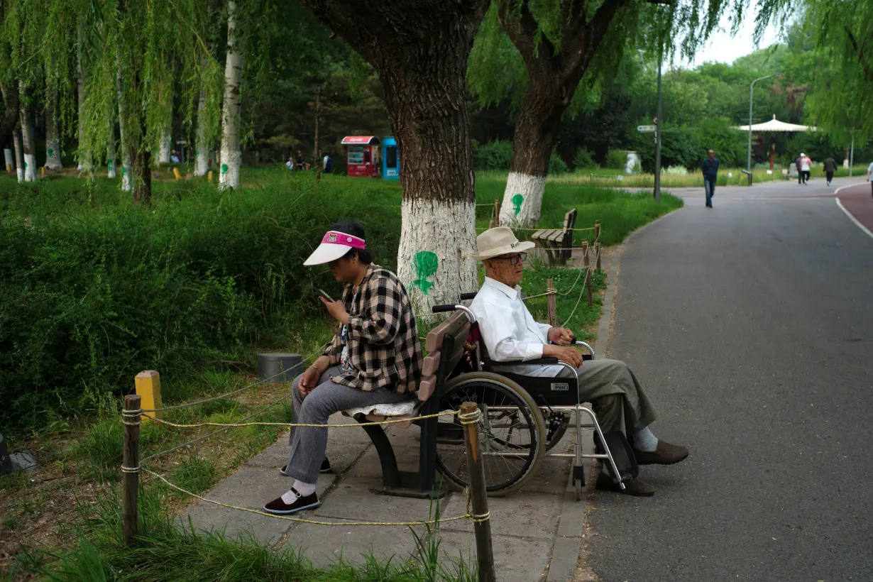 Elderly people rest at a park on a summer day in Beijing