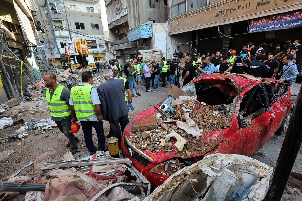 People gather at the site of an Israeli strike in Beirut's southern suburbs