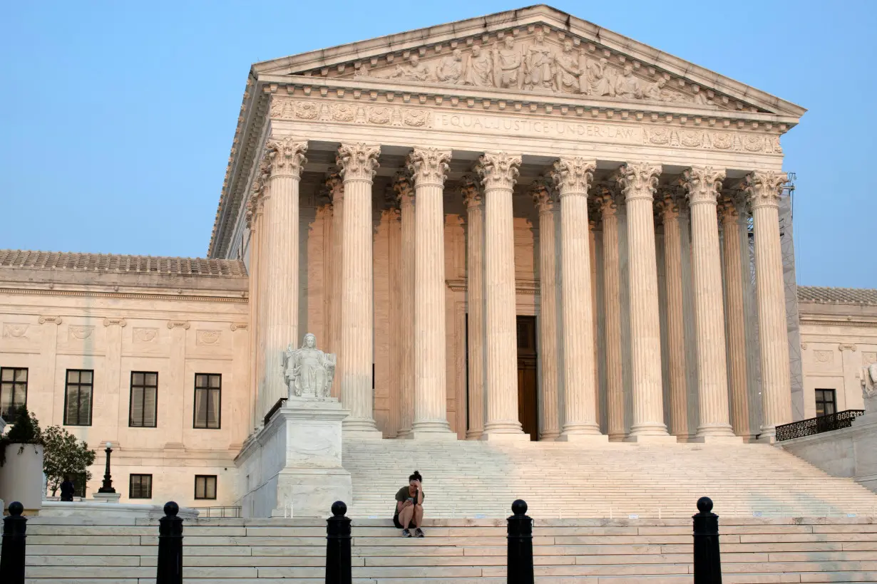 FILE PHOTO: A woman sits on the steps of the U.S. Supreme Court