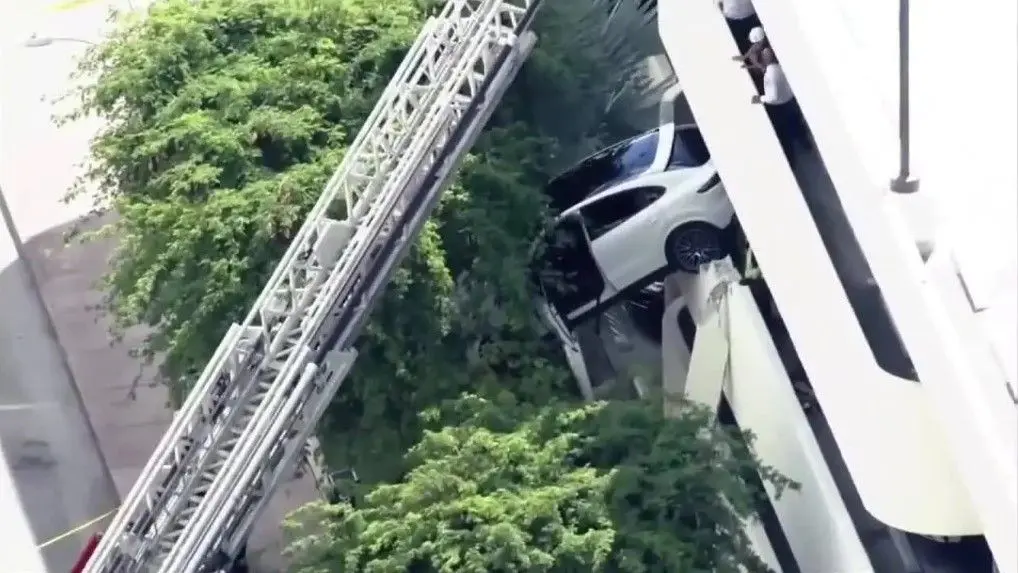 Crews rescue woman after car dangles off parking garage in Florida