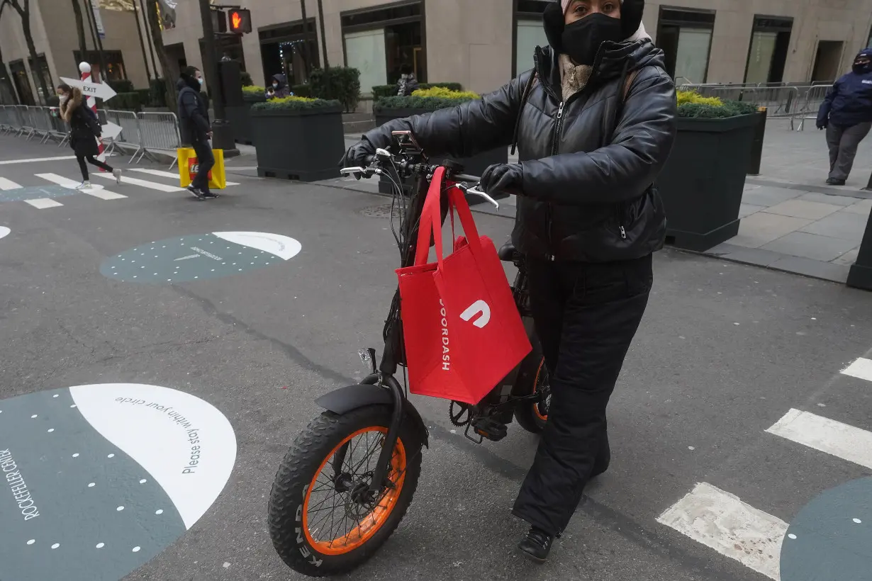 A DoorDash delivery person is pictured on the day they hold their IPO