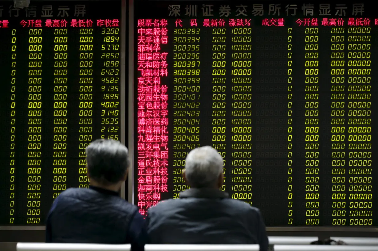 Investors wait for China's stock market to open in front of an electronic board at a brokerage house in Beijing