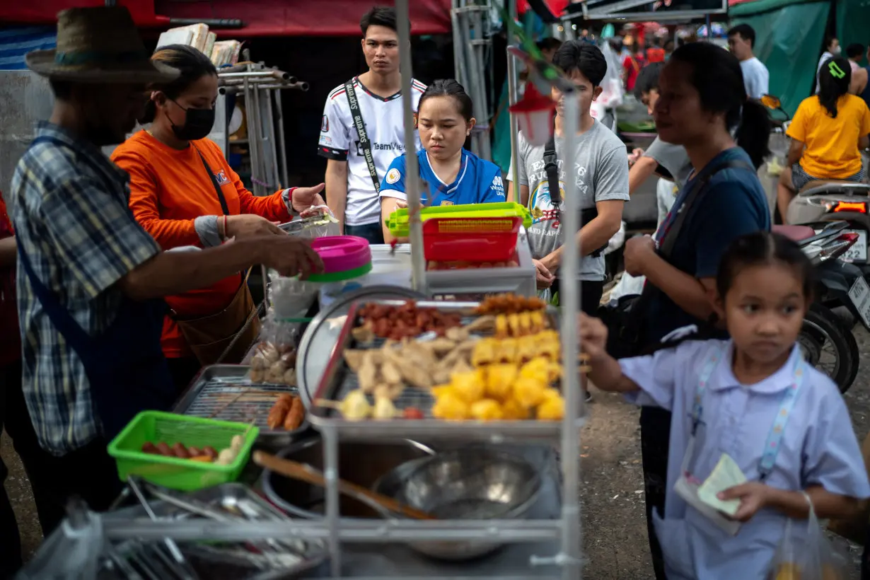 People buy street food at a market as Thailand is to inject $15.2 bln into economy next year through its digital wallet policy, in Bangkok