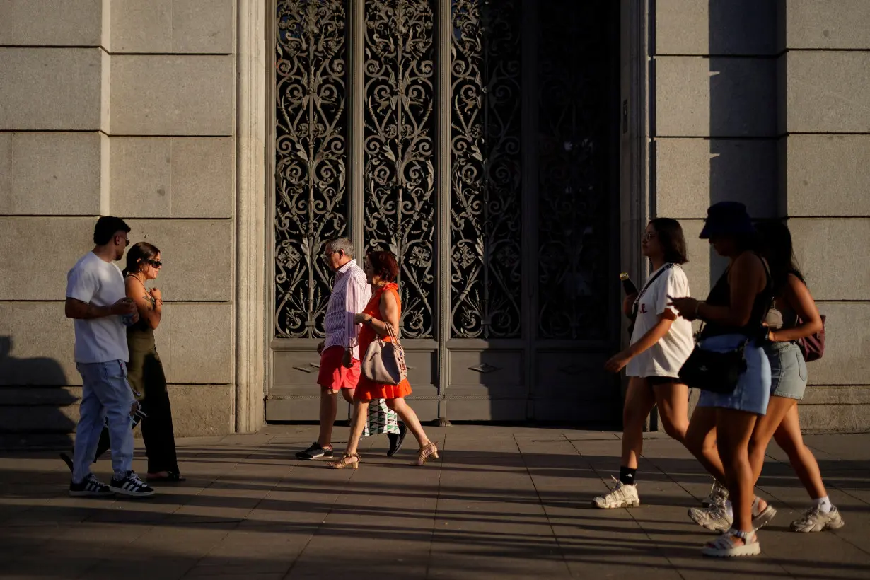 People walk along Alcala street in Madrid