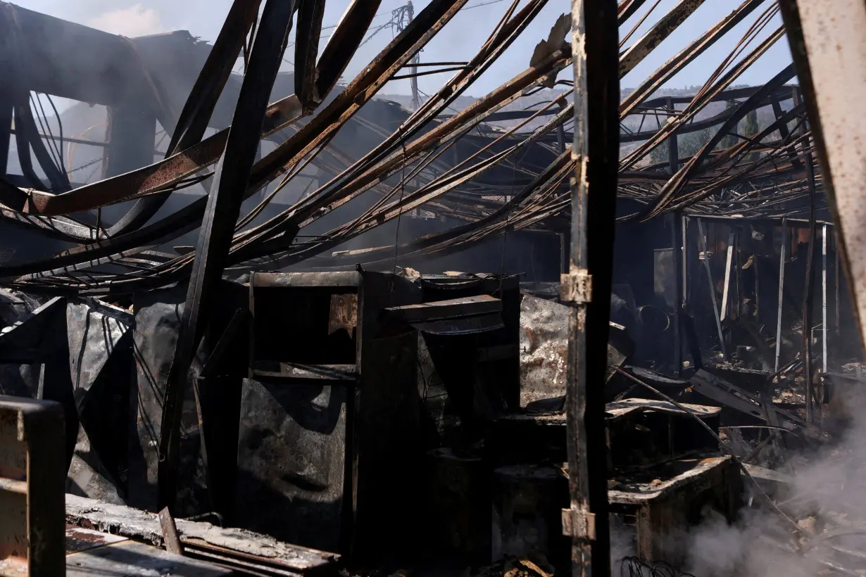 Firefighters work at the site of a damaged city government building in Kiryat Shmona following a rocket attack from Lebanon