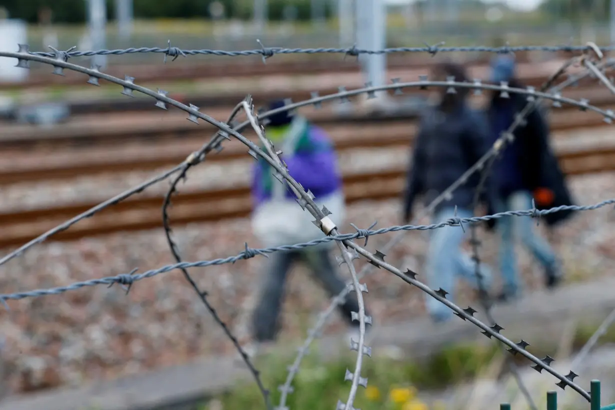 FILE PHOTO: Razor-wire frames migrants who walk near train tracks which lead to the Channel Tunnel in Frethun, near Calais