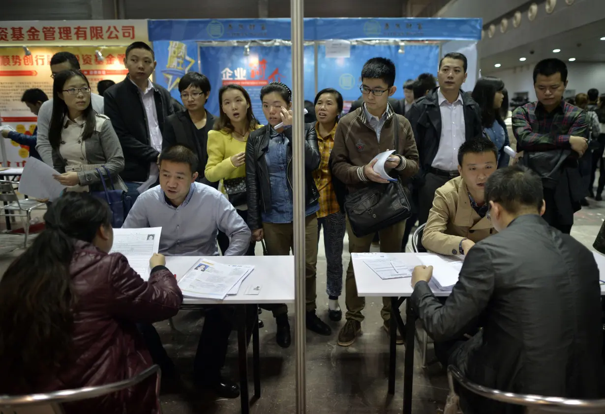 Job seekers speak to recruiters during their interviews at a job fair in Chongqing municipality