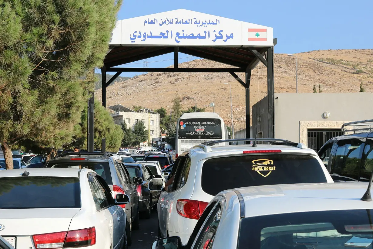 People fleeing Israeli bombings in Lebanon wait to enter Syria through the Masnaa crossing in eastern Lebanon on September 24.