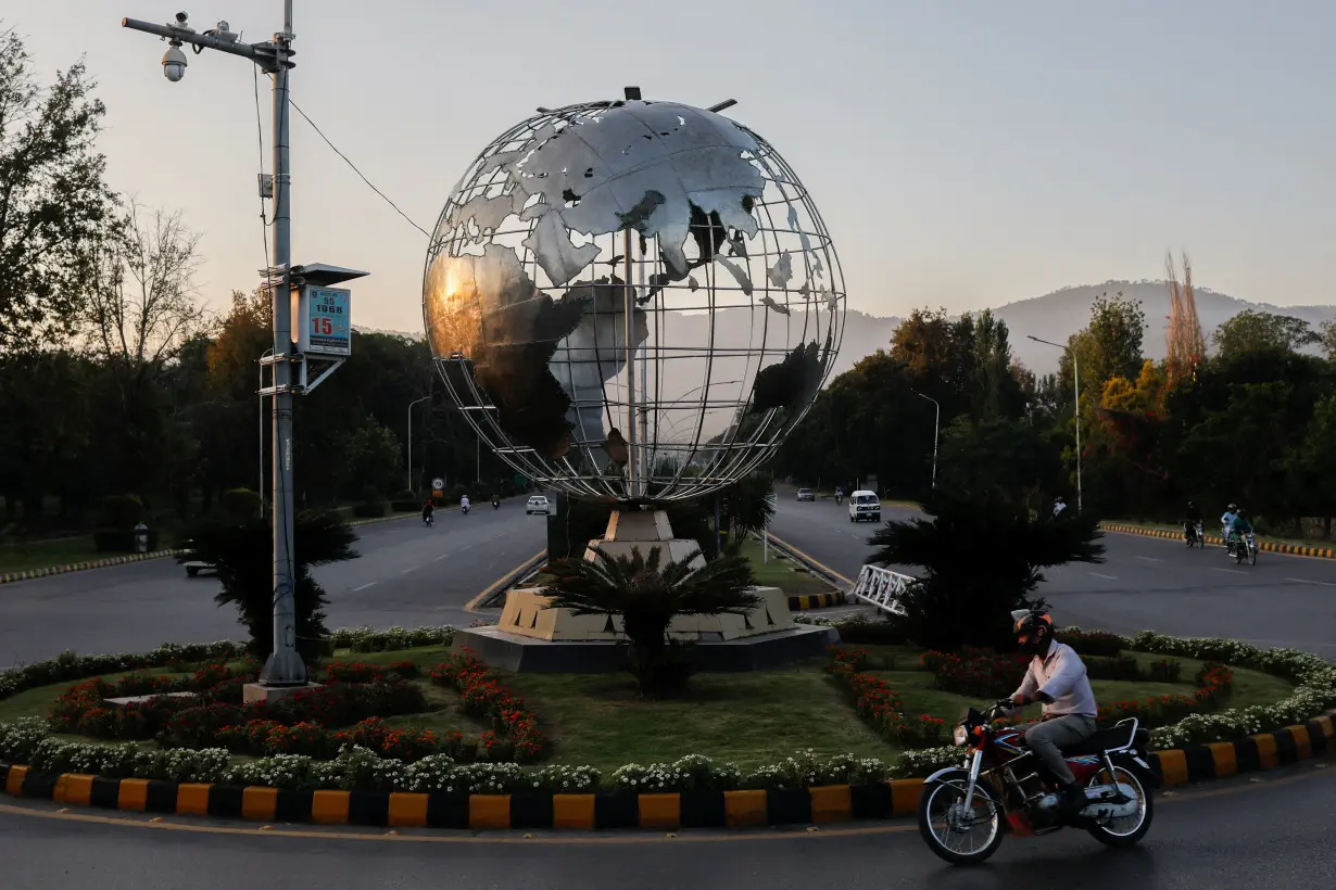 Man rides past Globe roundabout at the Constitution Avenue in Islamabad