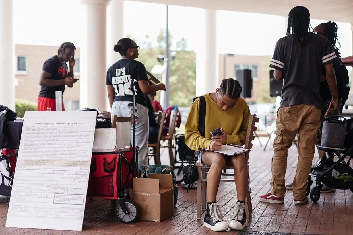 A Morehouse student fills out a voter registration form at a voter registration form at a voter registration booth at Morehouse College on August 19, in Atlanta, Georgia.