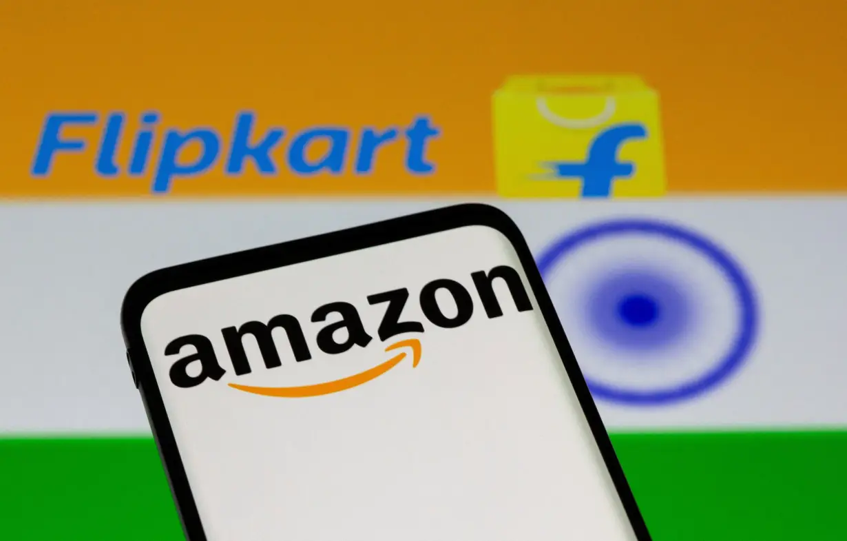 FILE PHOTO: Smartphone with Amazon logo is seen in front of displayed Flipkart logo and Indian flag in this illustration taken