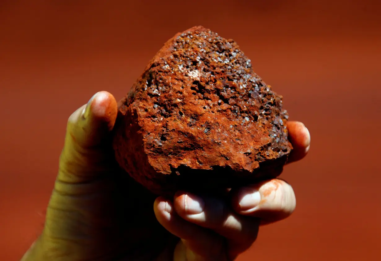 File photo of a miner holding a lump of iron ore at a mine located in the Pilbara region of Western Australia