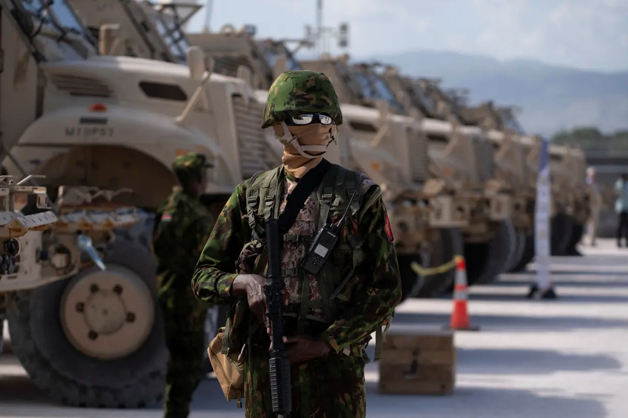 FILE PHOTO: A Kenyan police officer stands next to a row of anti-mine armoured vehicles in Port-au-Prince, Haiti