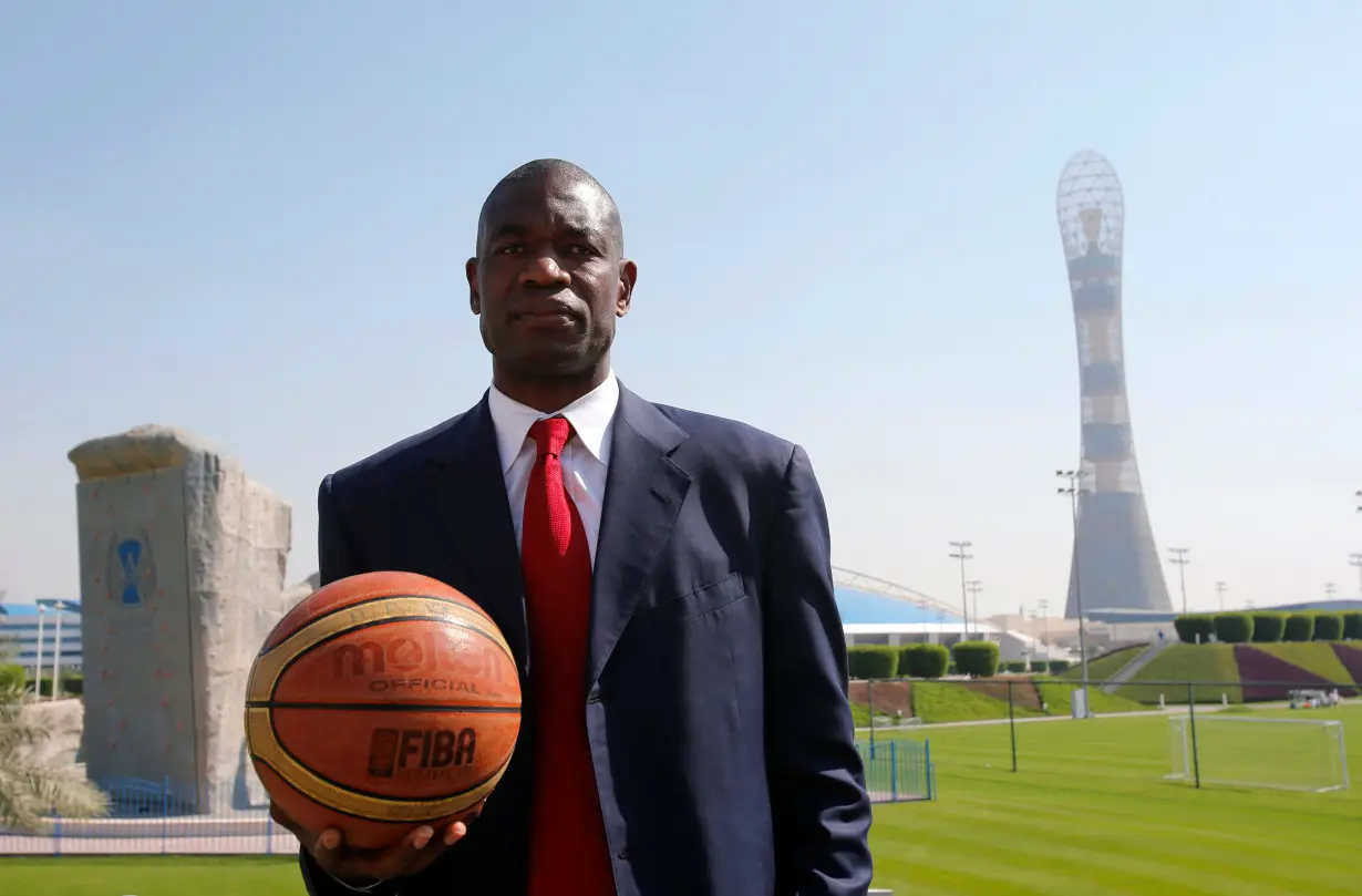 Former NBA star Mutombo of U.S. poses before a news conference at the Sports Congress and Exhibition at Aspire Dome in Doha