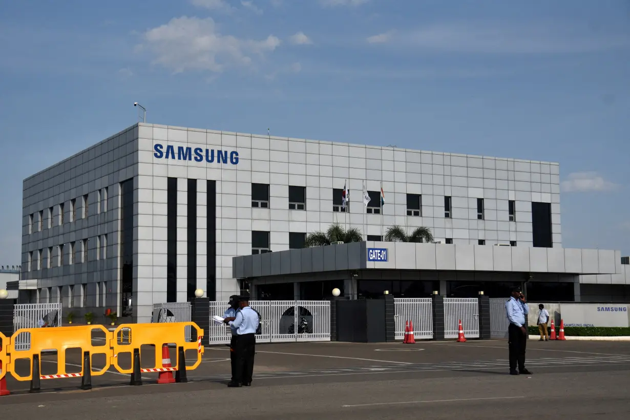 FILE PHOTO: Security guards stand outside a Samsung facility during a strike by the factory workers demanding higher wages in Sriperumbudur