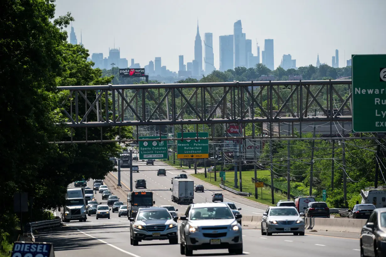 Cars drive along a highway during the Memorial Day weekend while the New York Skyline and the Empire State Building are seen in the background in Clifton, New Jersey