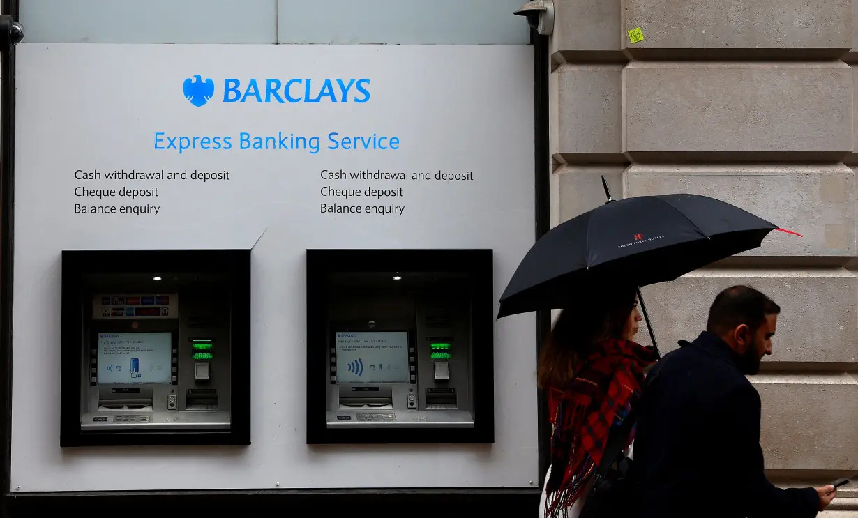 People walk past a branch of Barclays Bank in London