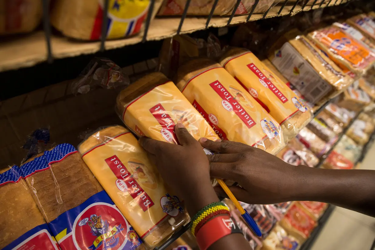 An employe holds loaves of bread at a supermarket in Nairobi