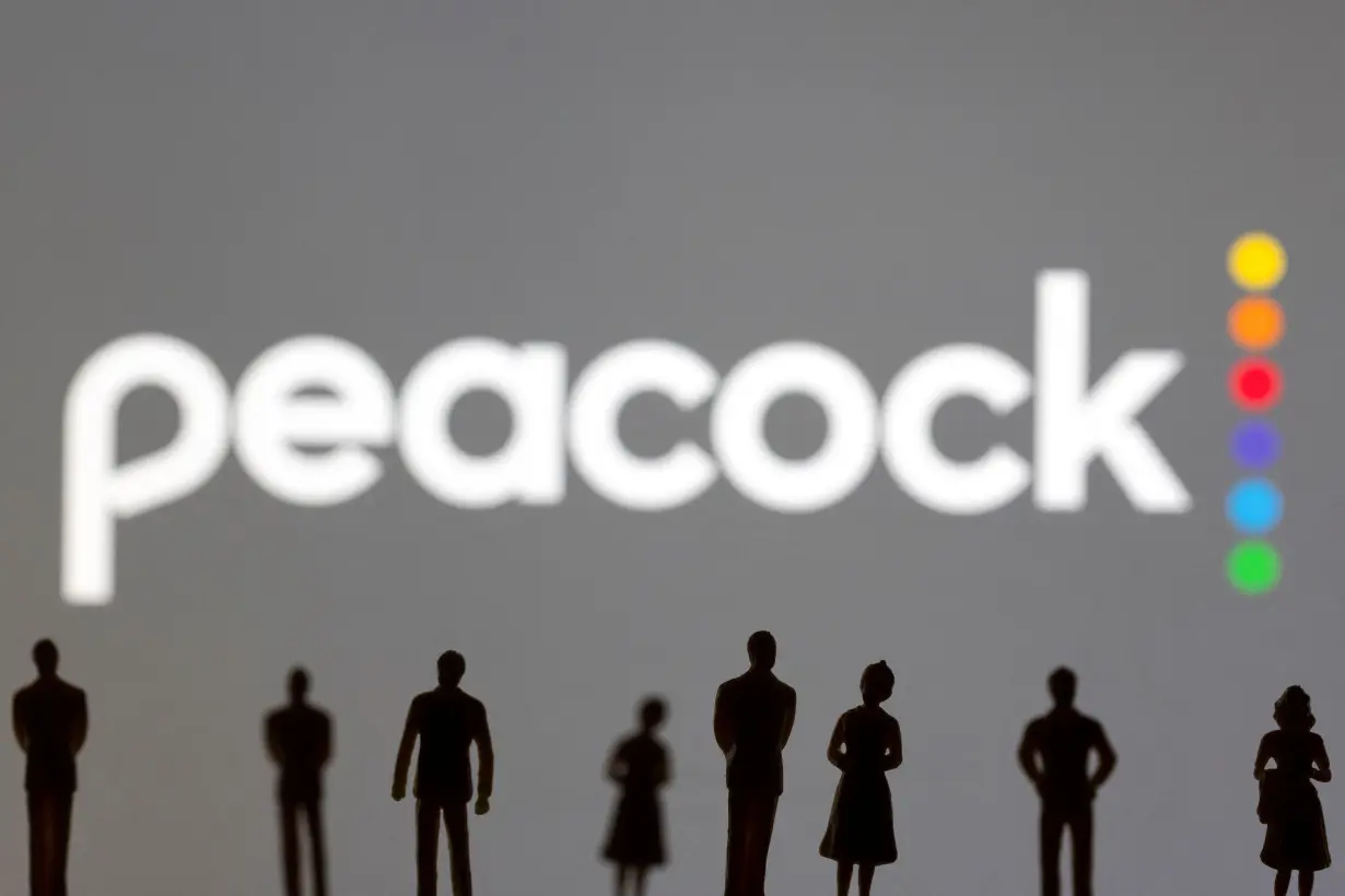 Toy figures of people are seen in front of the displayed Peacock logo, in this illustration