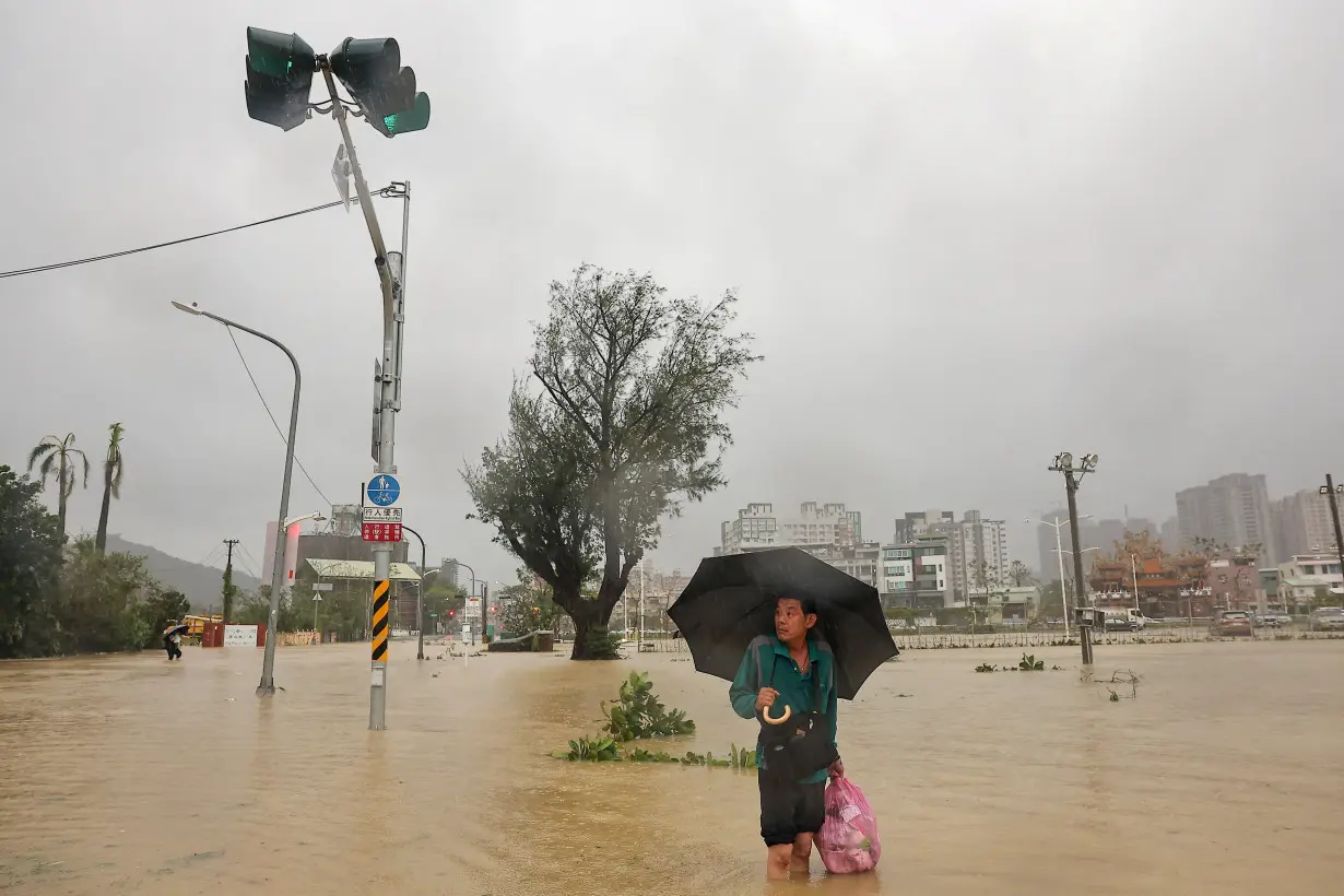 A person looks on as he wades through the floodwaters to work, after Typhoon Krathon made landfall, in Kaohsiung