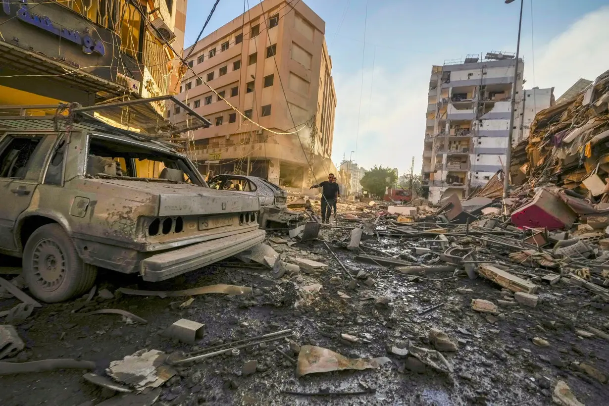 Residents run for cover following an Israeli airstrike in the Dahiyeh neighborhood of greater Beirut on October 4.