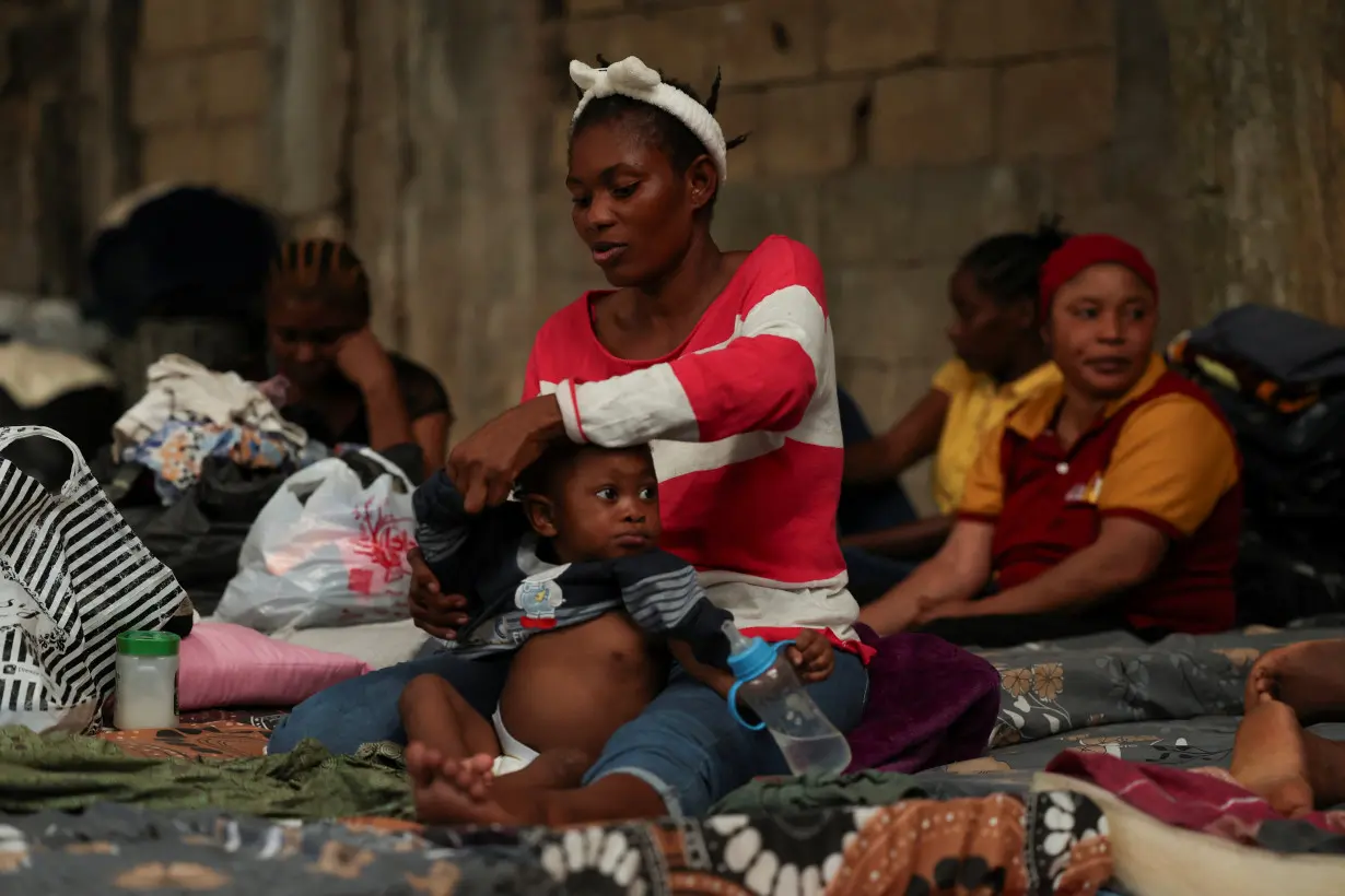 Mariatu Swarray, from Sierra Leone, dresses her one-year-old son at a shelter for displaced migrant workers, in Hazmieh