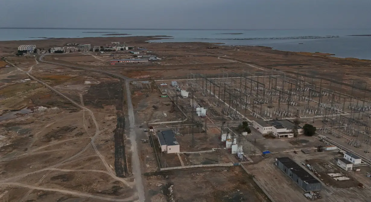 A drone view shows an electrical substation and the village of Ulken